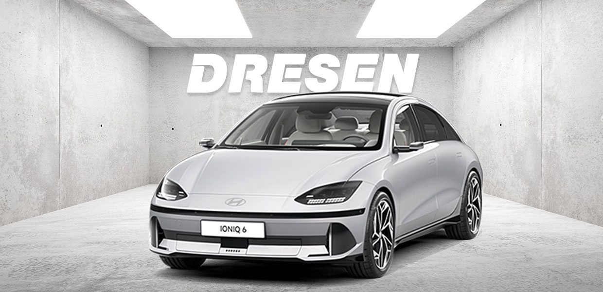 Grauer Hyundai Ioniq 6 vor Betonwand mit großem ‚DRESEN‘-Schriftzug darüber.