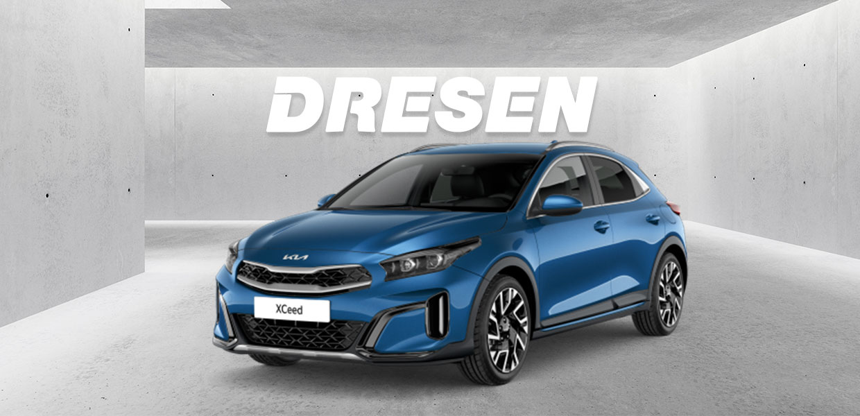 Blauer Kia X-Ceed vor Betonwand mit großem ‚DRESEN‘-Schriftzug darüber.