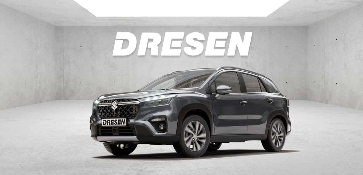 Grauer Suzuki Scross vor Betonwand mit großem ‚DRESEN‘-Schriftzug darüber.